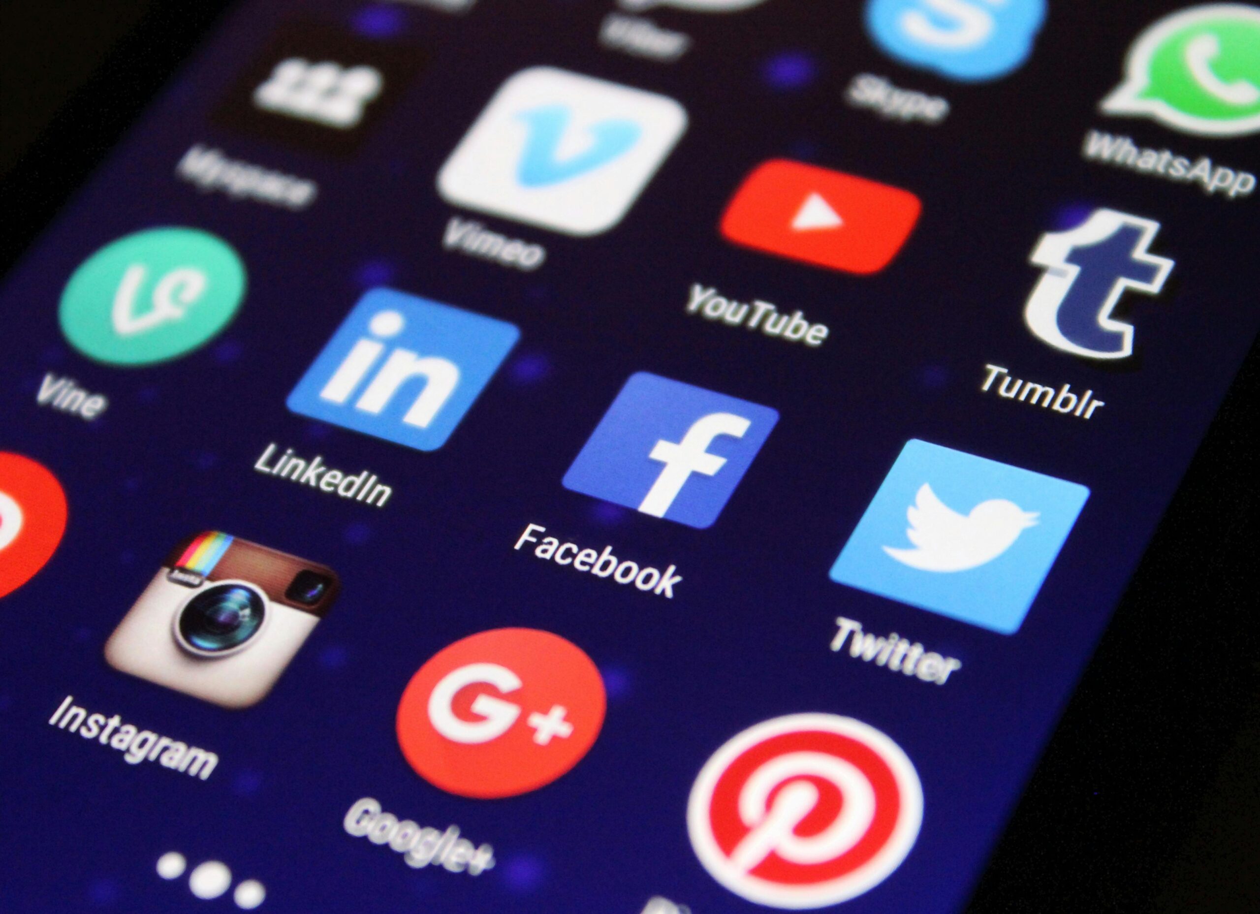 Free Website Offer to Fife Businesses Close-up of a smartphone screen showing various social media app icons such as Facebook and Twitter.
