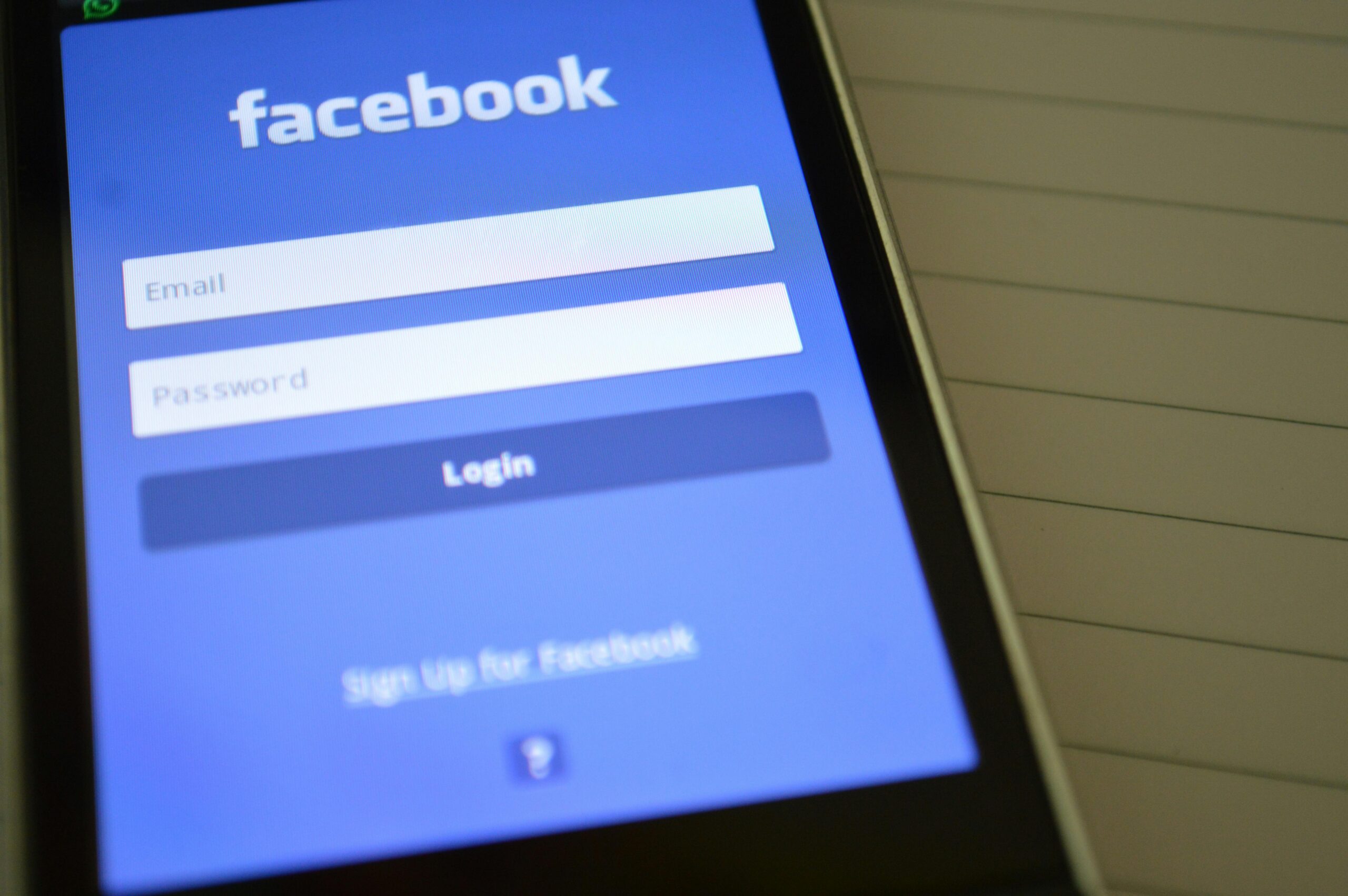 How to close a duplicate Facebook account Mobile phone with Facebook login screen, highlighting digital connectivity and social media use.