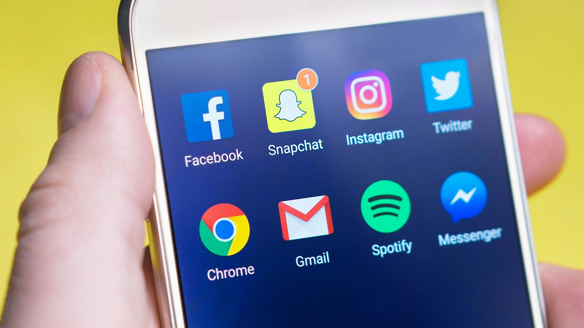 3 key reasons not to rely on Facebook for your business advertising A person's hand holding a smartphone displaying social media and communication apps.
